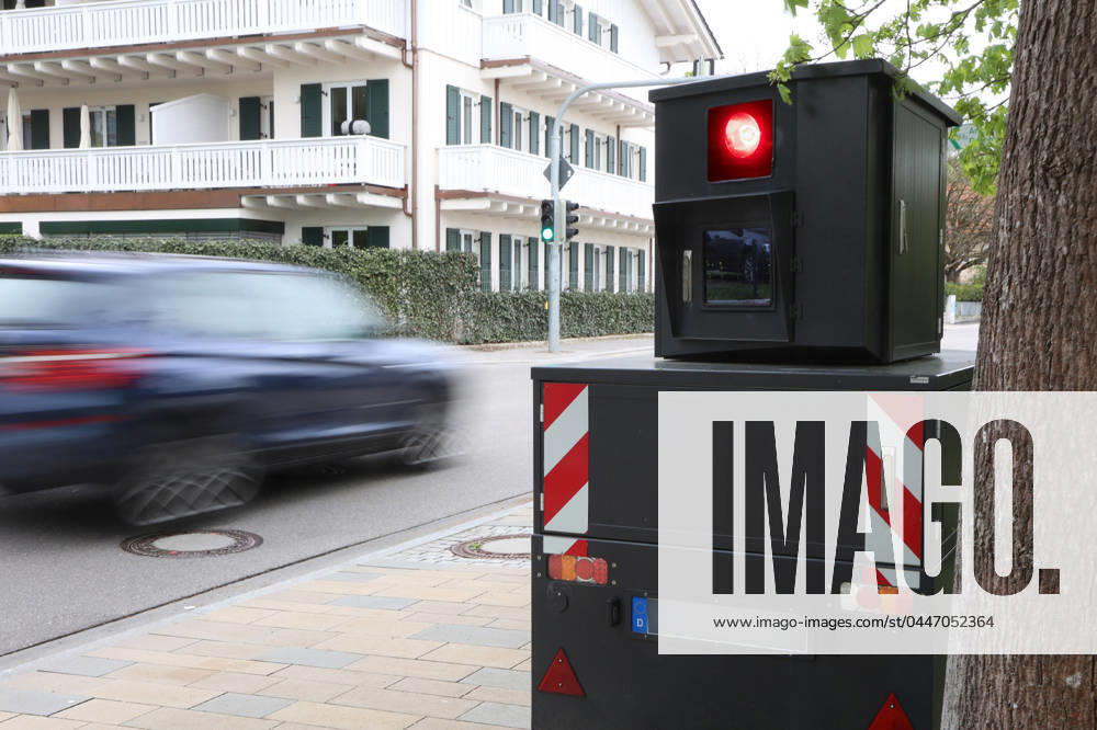 Bayern, Deutschland 19. April 2024: Ein Blitzer, Rotlichtüberwachung, Geschwindigkeitsüberwachung, Blitzer Anhänger an einer Strasse mit vorbeifahrenden Autos, Blitzermarathon, Bussgeld, PKW, zu schnell, Raser, Tempolimit als Symbolbild, Auslöser, Rotlicht, geblitzt,Geschwindigkeitsmessung