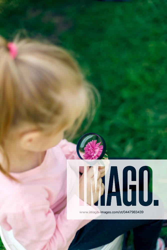 IMAGO Creative, Sommer, Sommertage im Garten A child examines a flower under a magnifying glass Chi?in?u, Chisinau, Moldova CR_WCIK24042116-1390972-01 ,model released, Symbolfoto