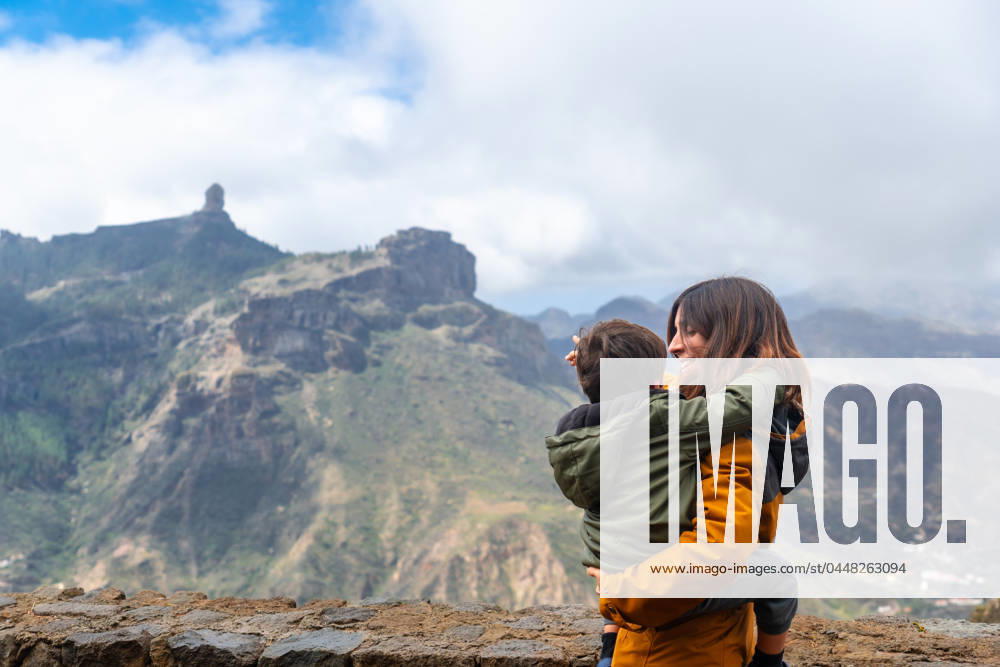 A mother with her son looking at Roque Nublo from a viewpoint. Gran Canaria, Spain, Europe