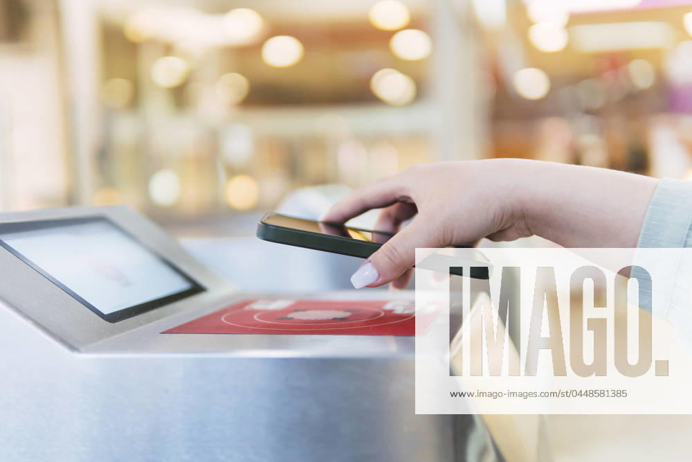 Hand of woman scanning QR code through smart phone at turnstile model released, Symbolfoto, PNAF06180