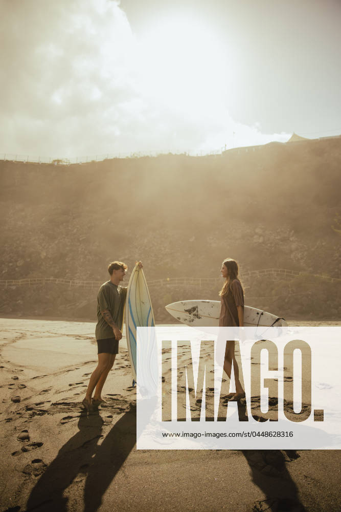 Couple with surfboards talking at beach on sunny day model released, Symbolfoto, ACPF01588