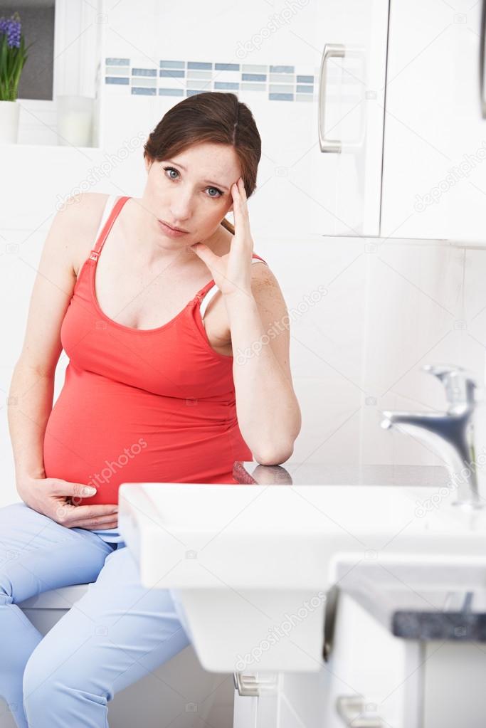 Pregnant Woman Suffering With Morning Sickness In Bathroom model released
