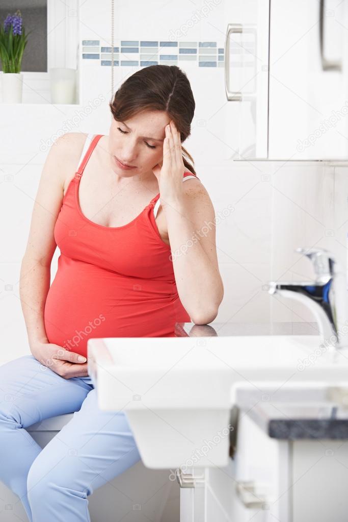 Pregnant Woman Suffering With Morning Sickness In Bathroom model released