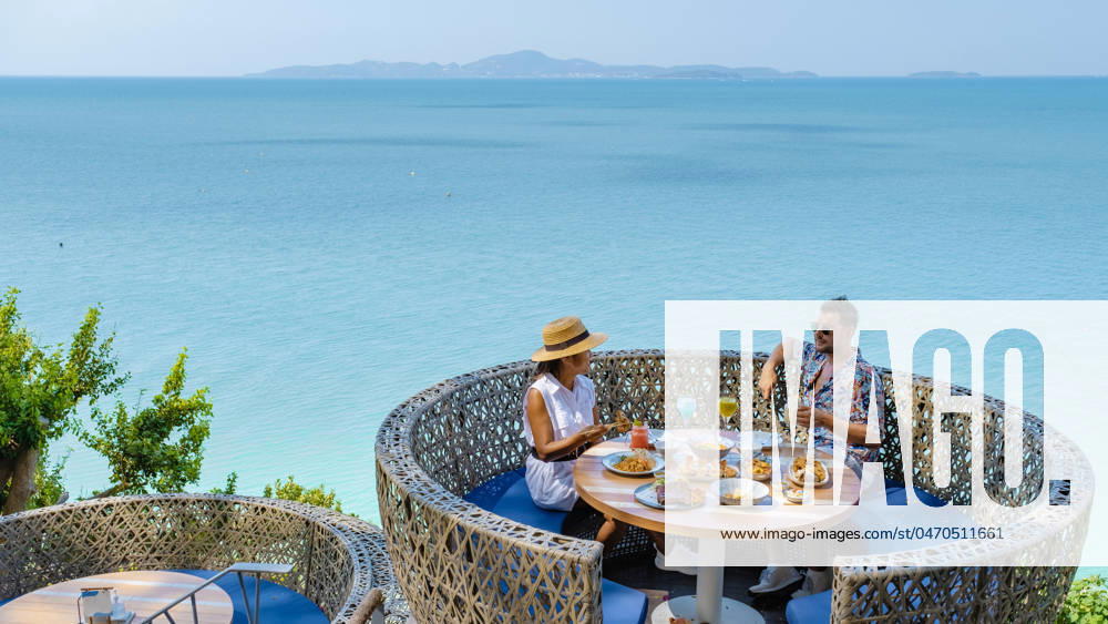Couple having lunch at an restaurant looking out over the ocean of Pattaya Thailand, man and woman having dinner in restaurant by the ocean in Pattaya couple having lunch at a restaurant looking out over the ocean of Pattaya Thailand, man and woman having dinner in a restaurant by the ocean in Pattaya.