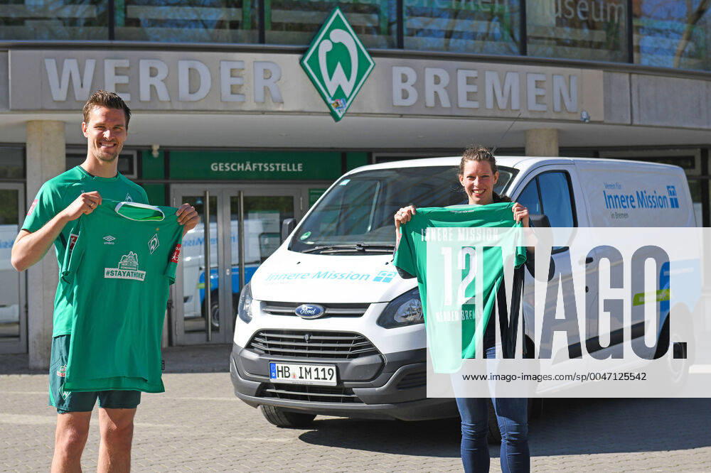 KW15 STAYATHOME-TRIKOT: WERDER SPENDET 20.000 EURO FÜR INNERE MISSION 09.04.2020, Trainingsgelaende am wohninvest WESERSTADION,, Bremen, STAYATHOME-TRIKOT: WERDER SPENDET 20.000 EURO FÜR INNERE MISSION, Das STAYATHOMETRIKOT ist der Verkaufsschlager in Werders Online-Shop. Die Grün-Weißen und ihr Hauptsponsor WIESENHOF haben das Sondertrikot mit der Botschaft, die Menschenleben rettet, in den Verkauf gegeben und dürfen sich über einen riesigen Ansturm freuen. Einer der großen Gewinner der Aktion ist der Verein für Innere Mission in Bremen. Fünf Euro spendet Werder Bremen von jedem Trikot an den Verein, der sich um Menschen in Notsituationen kümmert. Der Ansturm sorgt nach nur wenigen Tagen für die erste 20.000-Euro-Spende an den Verein. Am Donnerstagmittag, übergab Werder-Profi Sebastian Langkamp das Geld an Katharina Kähler, Bereichsleiterin für die Wohnungslosenhilfe des Vereins. im Bild Spende übergeben: Sebastian Langkamp und Katharina Kähler
