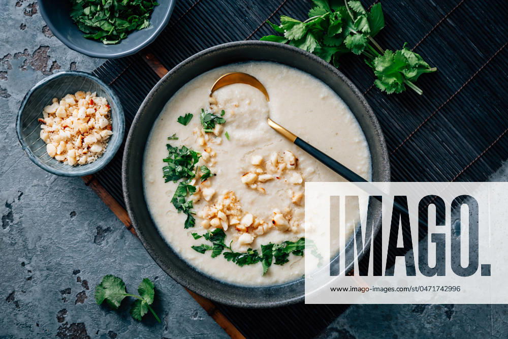 Spicy and creamy cauliflower and coconut soup with cilantro and macadamia nuts Spicy and creamy cauliflower and coconut soup with cilantro and macadamia nuts