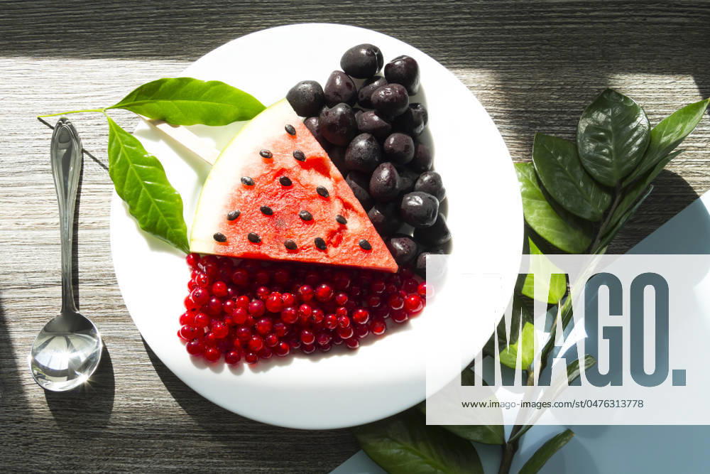 Summer snack. Fresh berries and fruits on a wooden table with green leaves of plants Summer snack. Fresh berries and fruits on a wooden table with green leaves of plants.