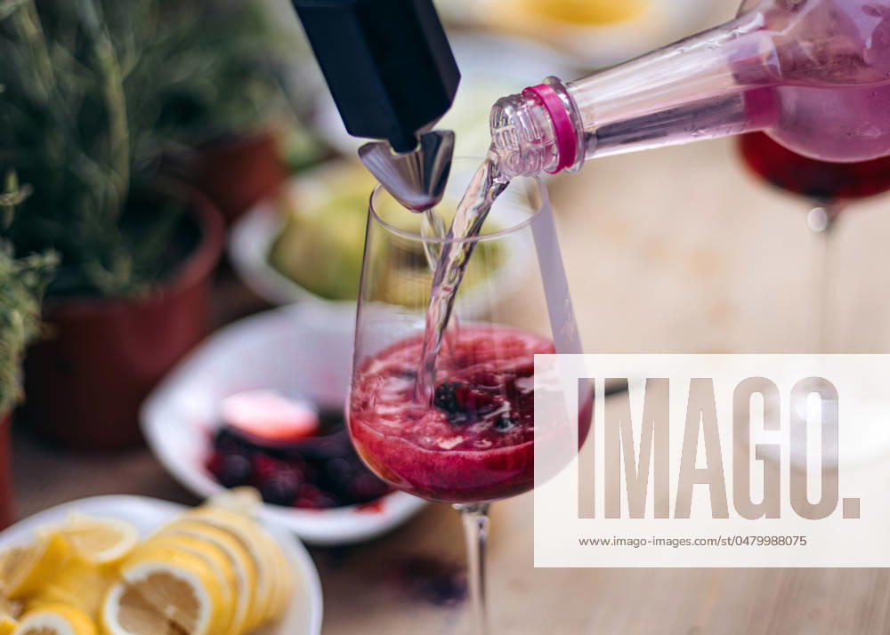 IMAGO Creative, Lifestyle, Feste im Garten #2 Pouring a refreshing berry drink into a glass Kirchberg in Tirol, Tyrol, Austria R_MGTP240519-1377094-01