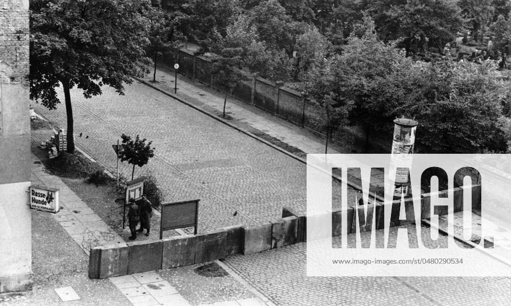 Bau der Berliner Mauer Erste Betonblockaden in der Strelitzer Str., Berlin 1961. - Originale Bildbeschreibung: Am 13. August 1961 wurde das östliche KZ geschlossen - Mit Panzern, Wasserwerfern und einem Riesenaufgebot an bewaffneteten Volkspolizisten schloß der OSten in der vergangenen Nacht die Grenzen zwischen Ost- und West-Berlin. Stacheldrahtverhaue, Betonmauern und zugemauerte Türen sollten unsere Landsleute im Osten daran hindern, die Deutsche Demokratische Republik mit dem kapitalistischen Westen zu vertauschen. - U.B.z.: Blick in die Strelitzer Straße , Berlin