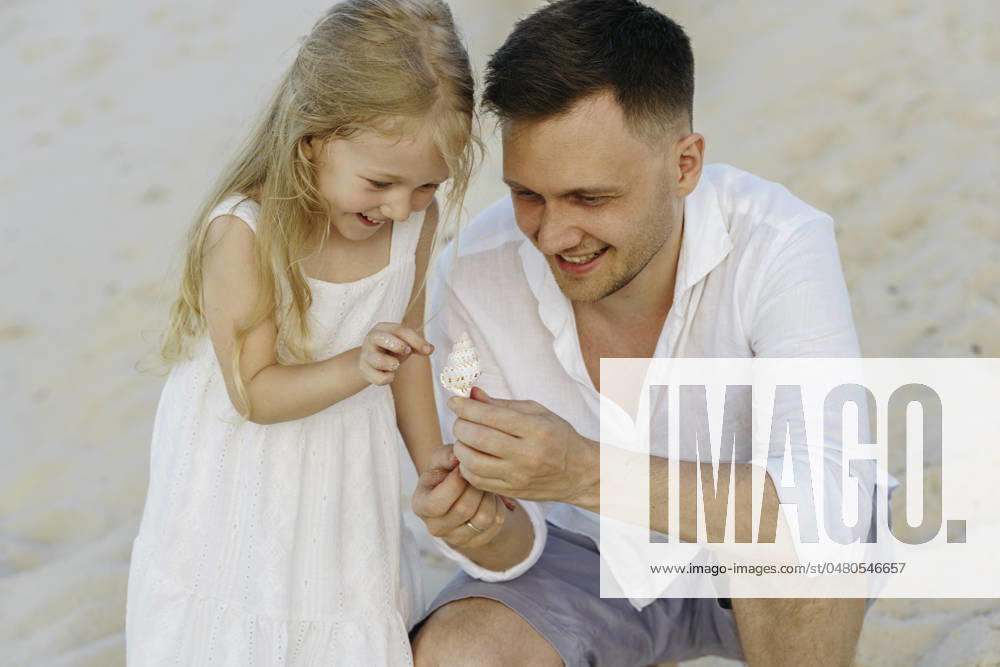 Happy father showing shell to daughter at beach model released, Symbolfoto, NSTF00132