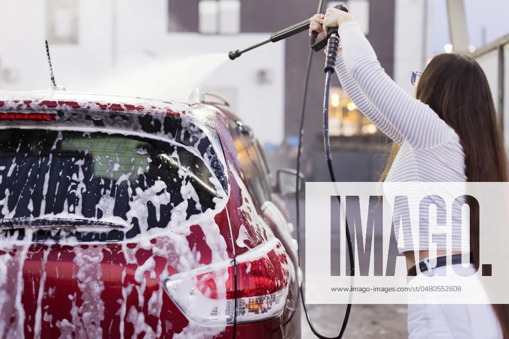 Woman cleaning car through high pressure water at garage model released, Symbolfoto, ONAF00792