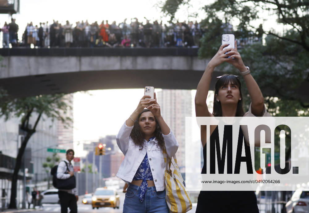 Revelers holding cameras and cell phones gather on 42nd street for a Manhattanhenge sunset event that disappointed due to overcast skies and cloud cover in New York City on Tuesday, May 28, 2024. The Manhattanhenge sunset comes twice a year when the setting sun aligns precisely with Manhattan s street grid. NYP20240528166 JohnxAngelillo