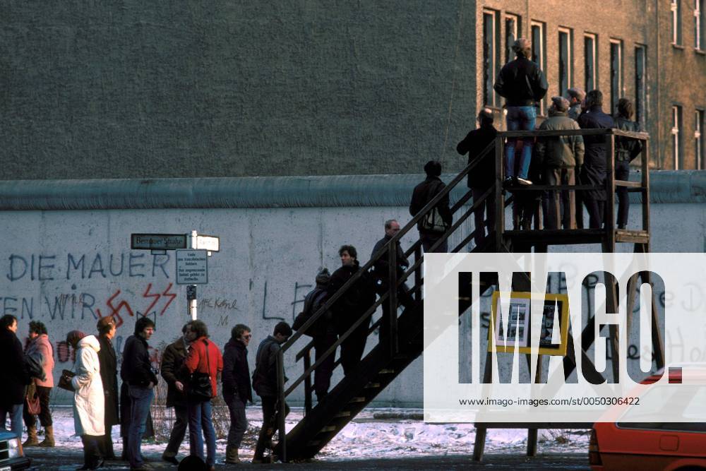 Westberliner schauen auf einer Aussichtsplattform über die Berliner Mauer anlässlich des Reaganbesuchs 1987