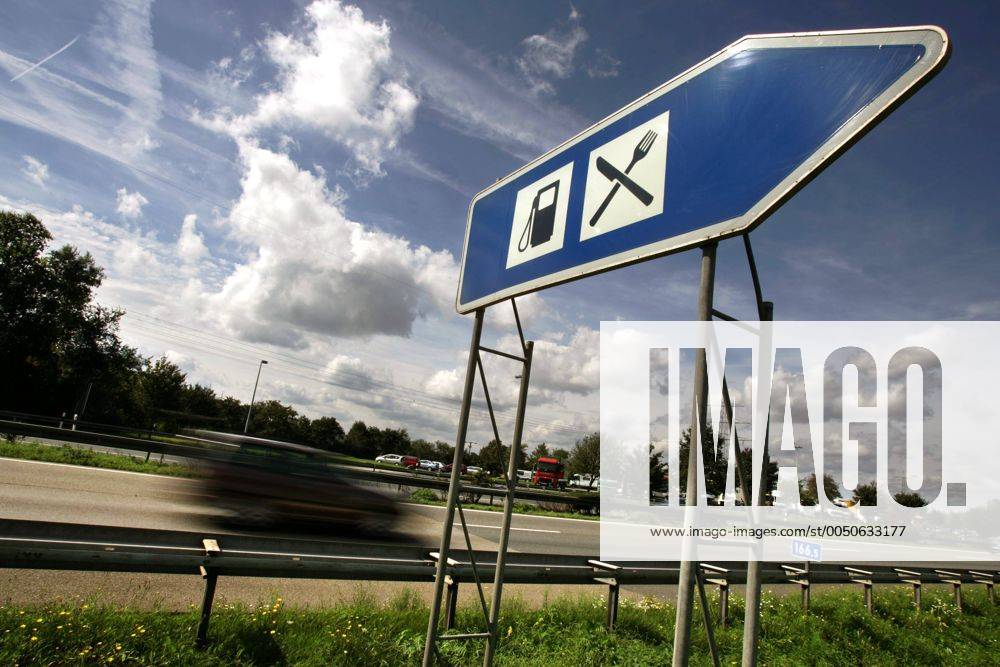 Rast-und Tankstelle - Hinweisschild an einer Autobahn mit vorbeifahrendem PKW