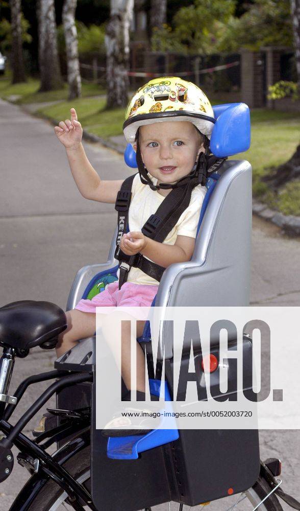 Kleines Mädchen sitzt mit Sturzhelm auf einem Kettler-Fahrradsitz