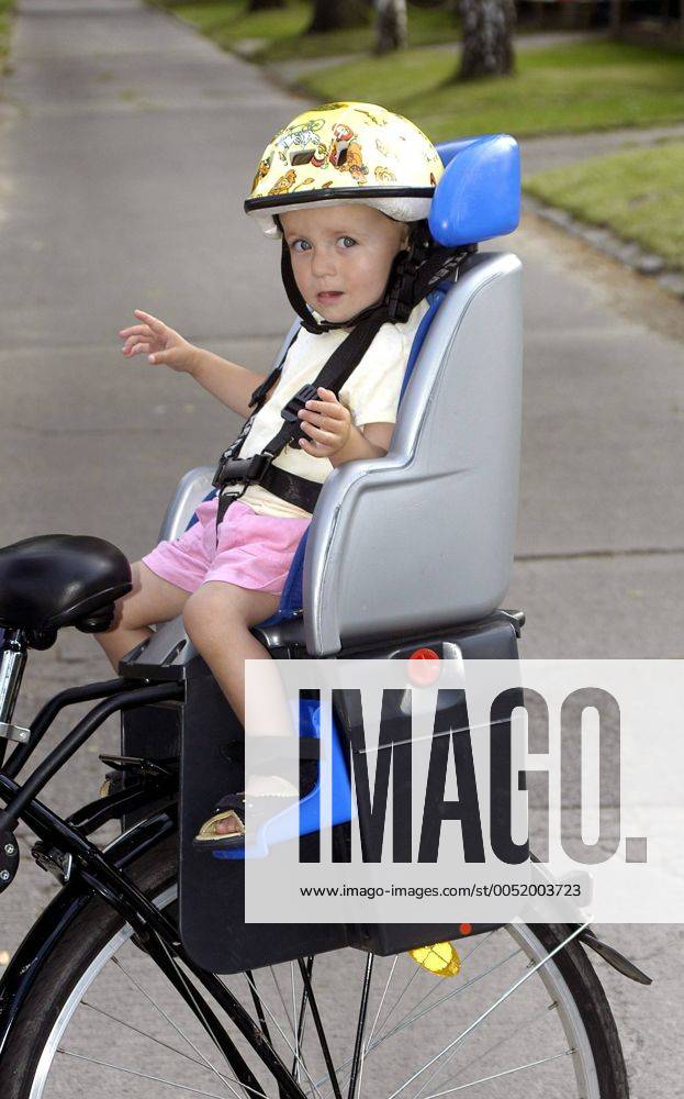 Kleines Mädchen sitzt mit Sturzhelm auf einem Kettler-Fahrradsitz