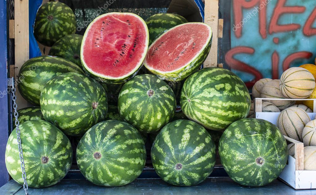 Watermelons on shelf. Cutted watermelon on street market. Summer Fruits.