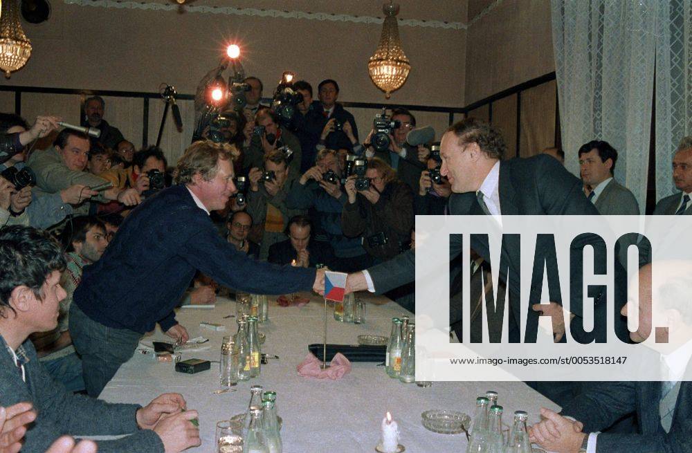 Playwrite and the representative of Civic Forum Vaclav Havel (L) shakes hands with Secretary of the government Marian Calfa. Other politicians, actors and the singer Michael Kocab are looking on in Prague, Czechoslovakia on Nov. 26, 1989.