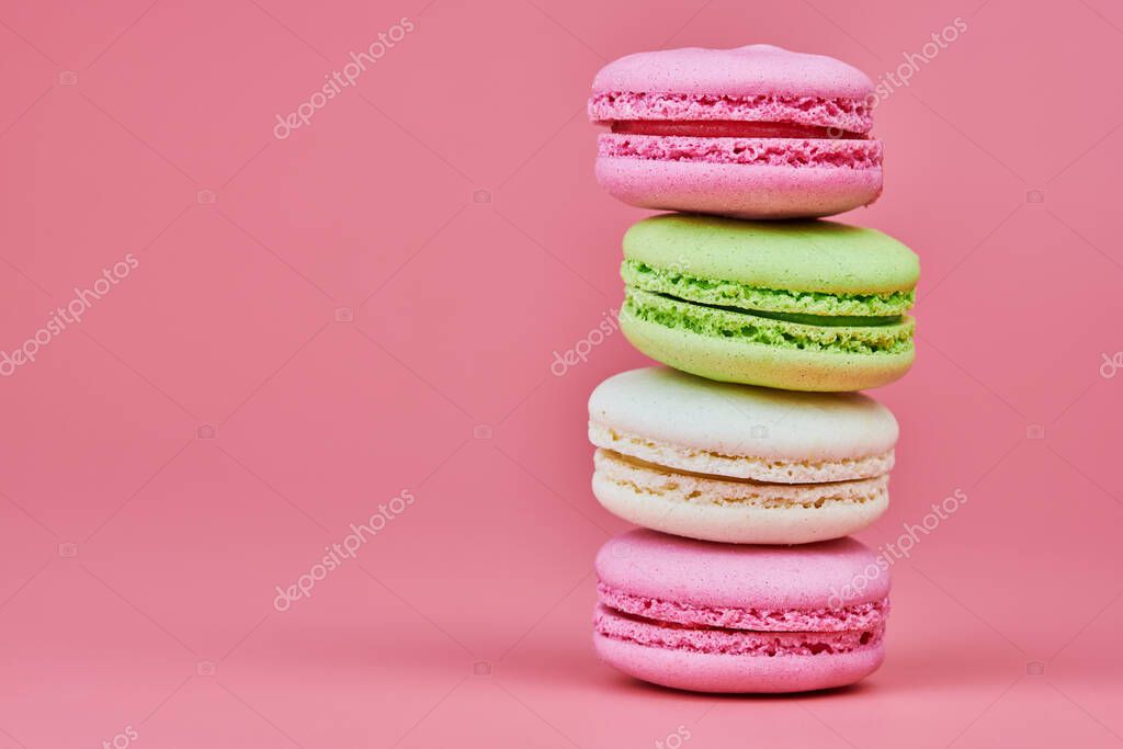 Macaroons on pink background. Colorful small cookie from ground almonds and coconut. Popular confectionery. Tasty snack food for take away, copy space