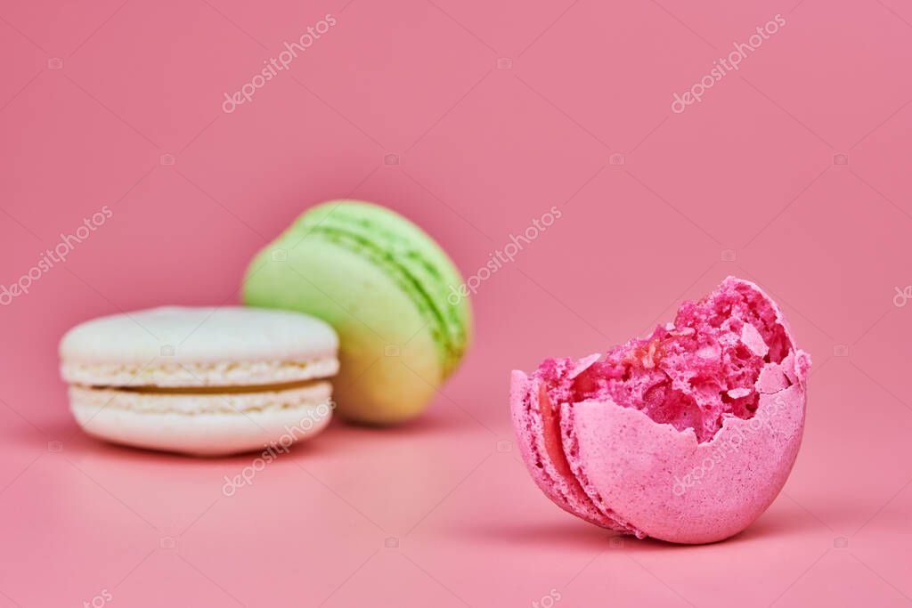 Macaroons on pink background. Colorful small cookie from ground almonds and coconut. Popular confectionery. Tasty snack food for take away, copy space
