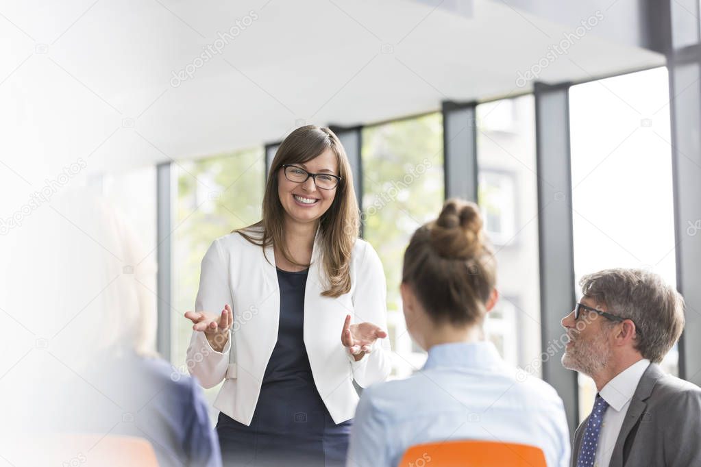 Smiling businesswoman planning strategy with colleagues during meeting at office model released