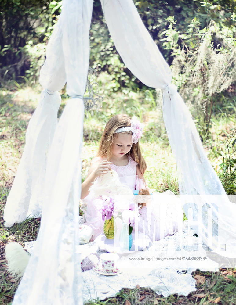 IMAGO Creative: Sommer, Sommertage im Garten Girl playing with kitten under lace canopy in a garden. United States, Florida, Floral City R_YWQX240605C-1449382-01 ,model released, Symbolfoto