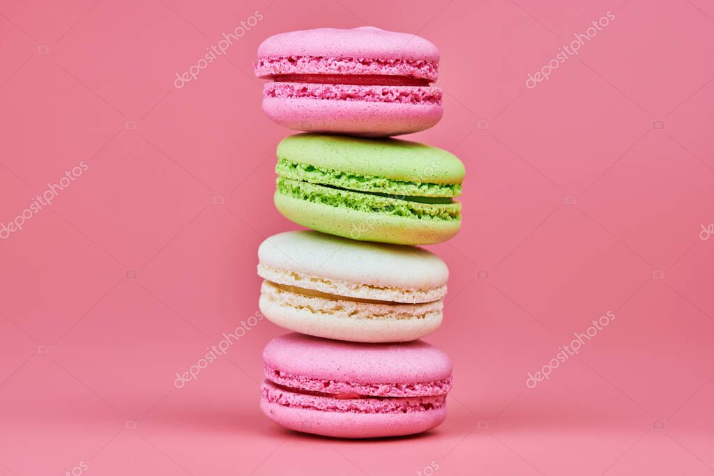 Macaroons on pink background. Colorful small cookie from ground almonds and coconut. Popular confectionery. Tasty snack food for take away, copy space