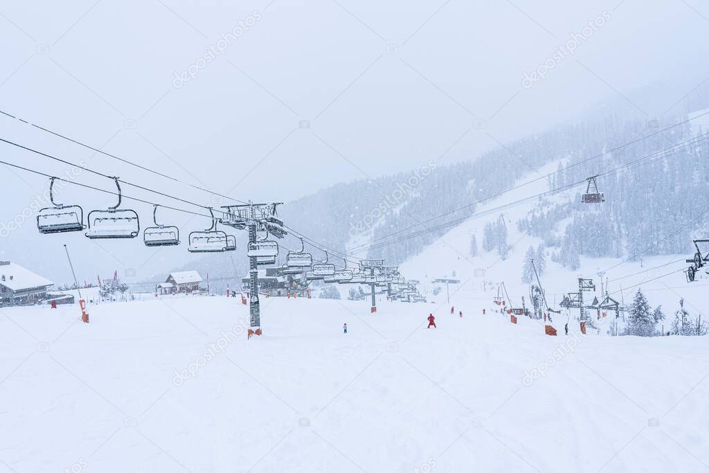 Auron, FRANCE - 01.01.2021: Empty ski slopes and ski lifts in ski resort. During the winter holidays 2021 January lifts are closed for skiing for adults due to the coronavirus pandemic. Defocused