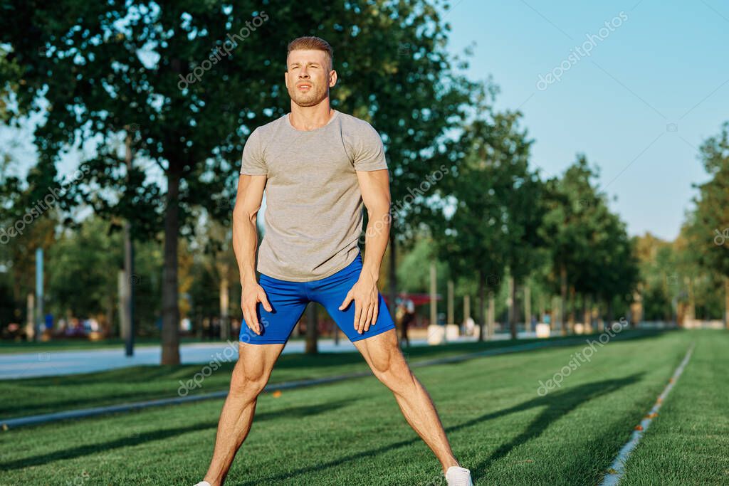 Sporty man in the park on the lawn exercise lifestyle. High quality photo model released