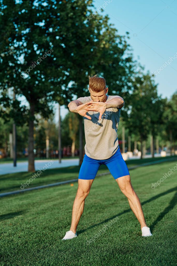 Sporty man in the park on the lawn exercise lifestyle. High quality photo model released