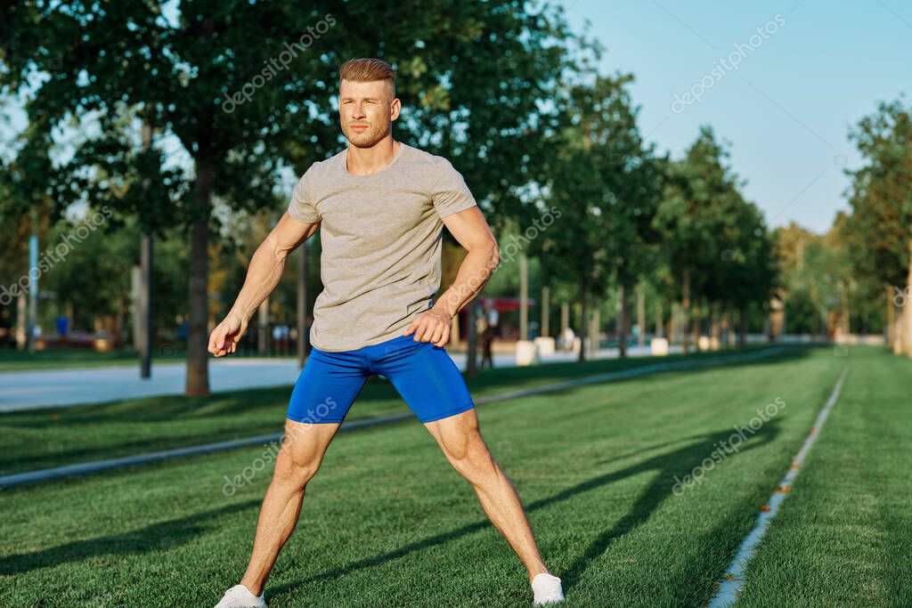 Sporty man in the park on the lawn exercise lifestyle. High quality photo model released