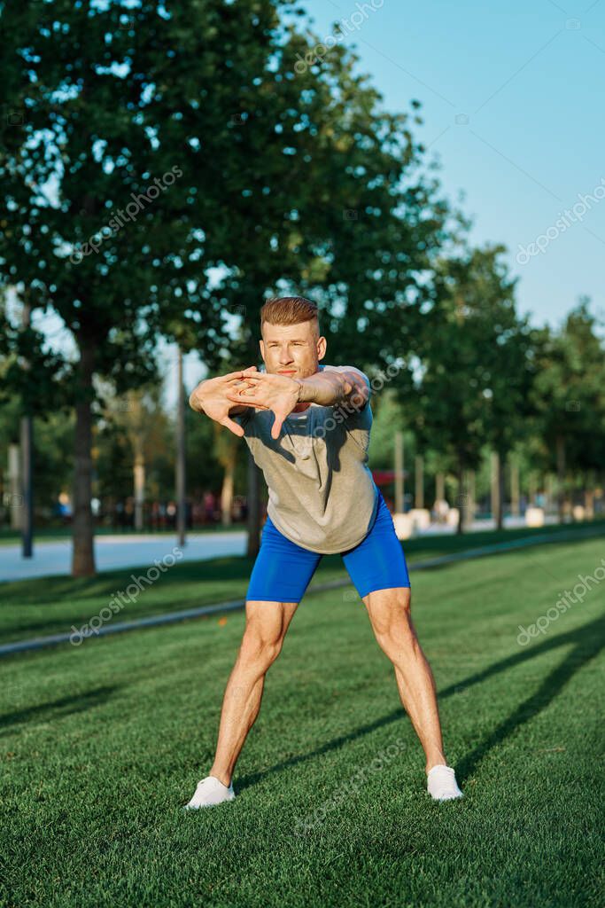 Sporty man in the park on the lawn exercise lifestyle. High quality photo model released