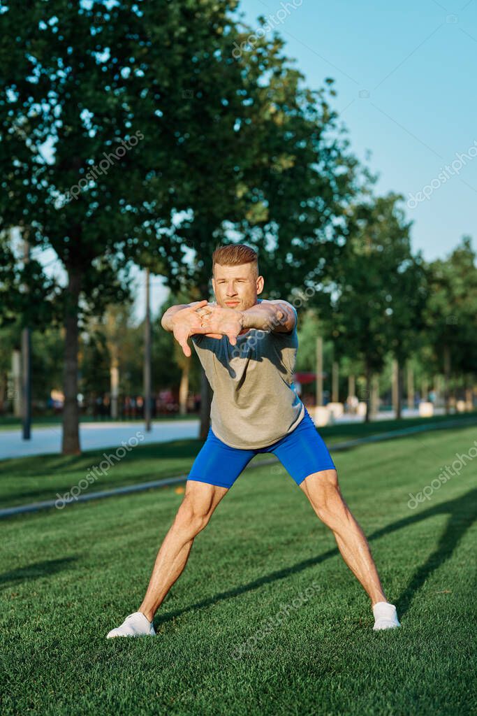 Sporty man in the park on the lawn exercise lifestyle. High quality photo model released