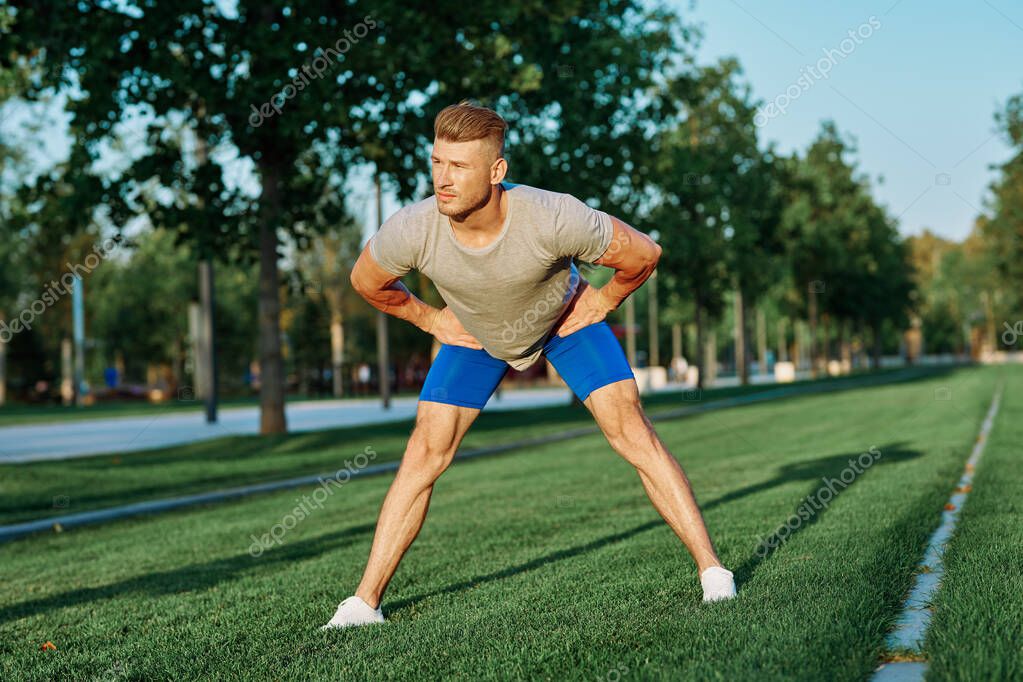 Sporty man in the park on the lawn exercise lifestyle. High quality photo model released