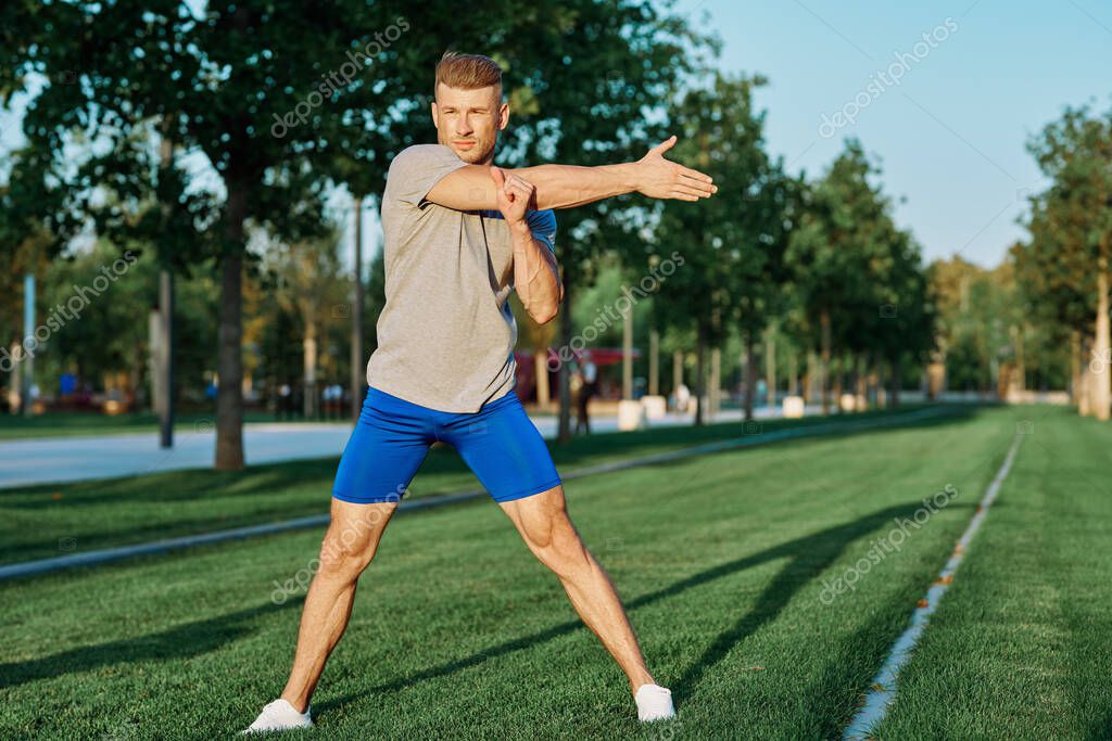 Sporty man in the park on the lawn exercise lifestyle. High quality photo model released