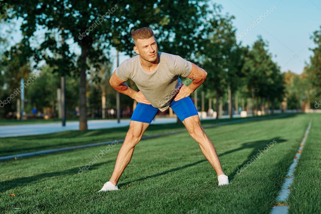 Sporty man in the park on the lawn exercise lifestyle. High quality photo model released