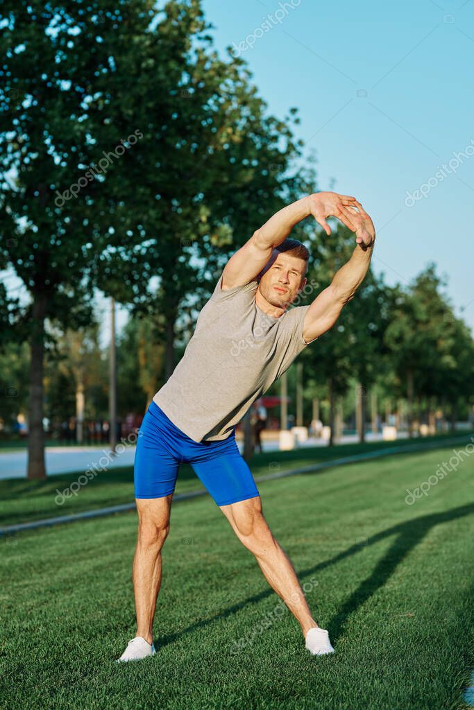 Sporty man in the park on the lawn exercise lifestyle. High quality photo model released