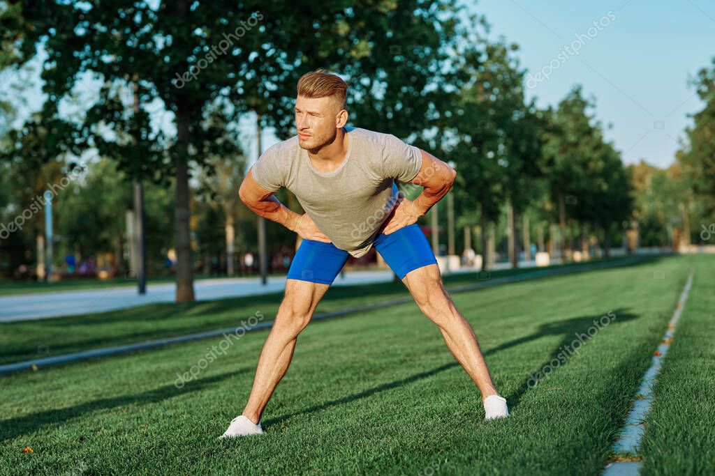 Sporty man in the park on the lawn exercise lifestyle. High quality photo model released