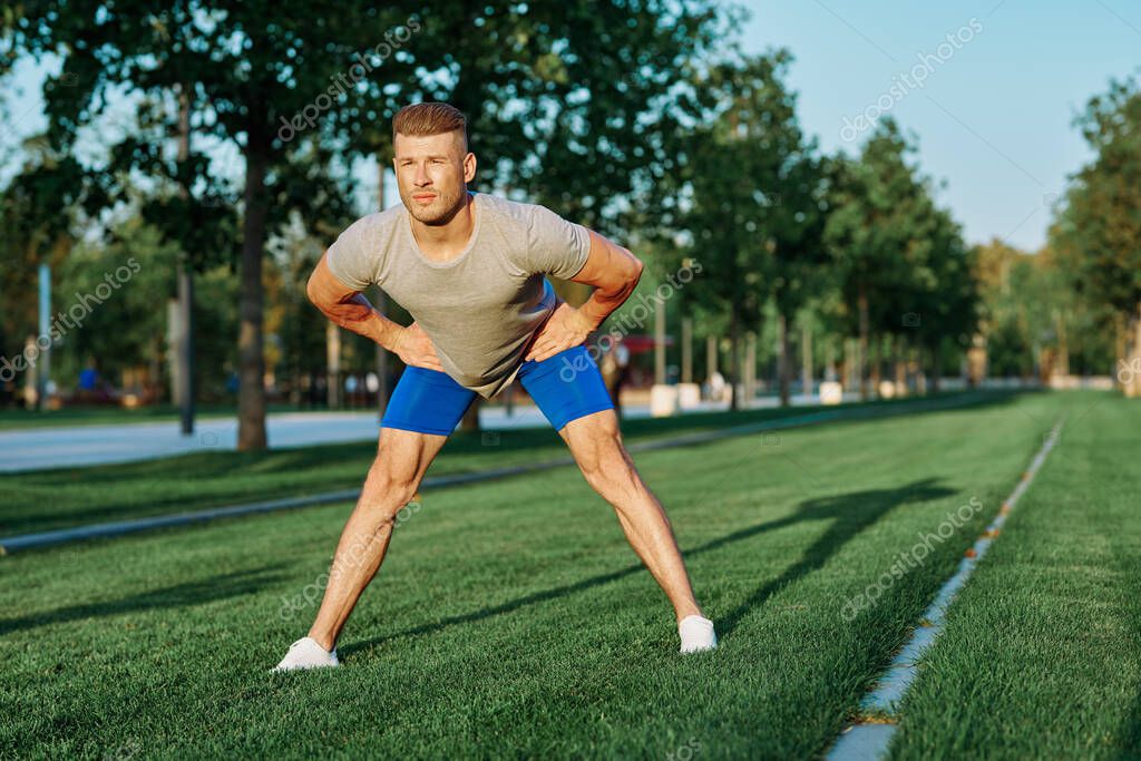 Sporty man in the park on the lawn exercise lifestyle. High quality photo model released