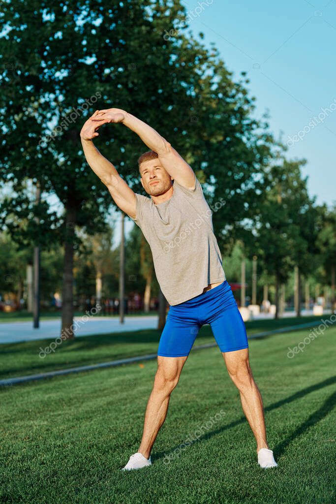 Sporty man in the park on the lawn exercise lifestyle. High quality photo model released