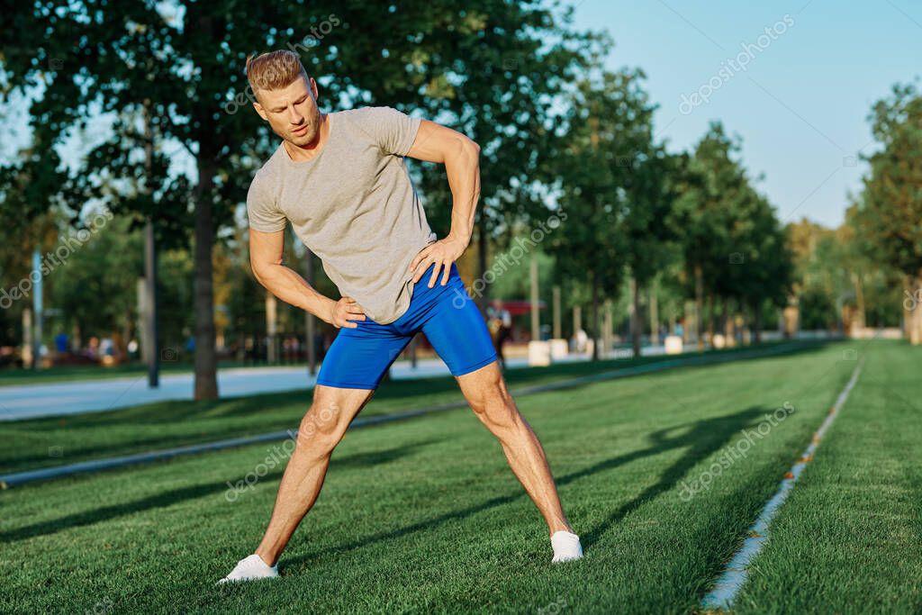 Sporty man in the park on the lawn exercise lifestyle. High quality photo model released