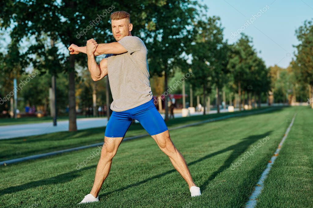 Sporty man in the park on the lawn exercise lifestyle. High quality photo model released
