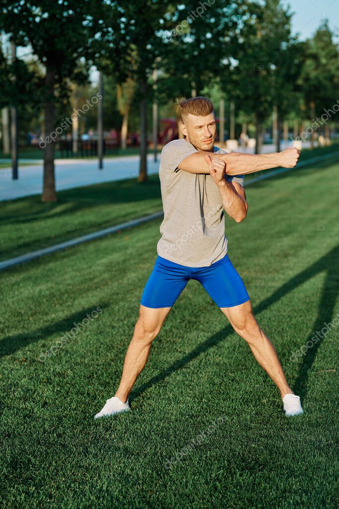 Sporty man in the park on the lawn exercise lifestyle. High quality photo model released