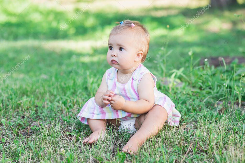 Adorable baby in multicolored dress in the park model released