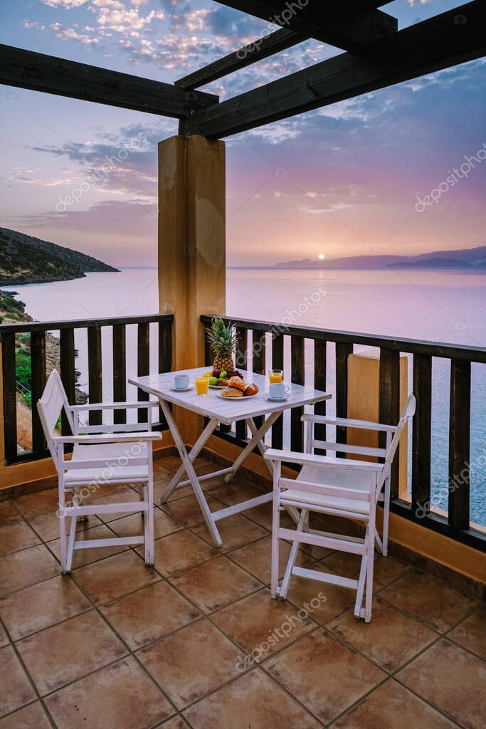 Table and chairs with breakfast during sunrise at the meditarian sea in Greece. High quality photo