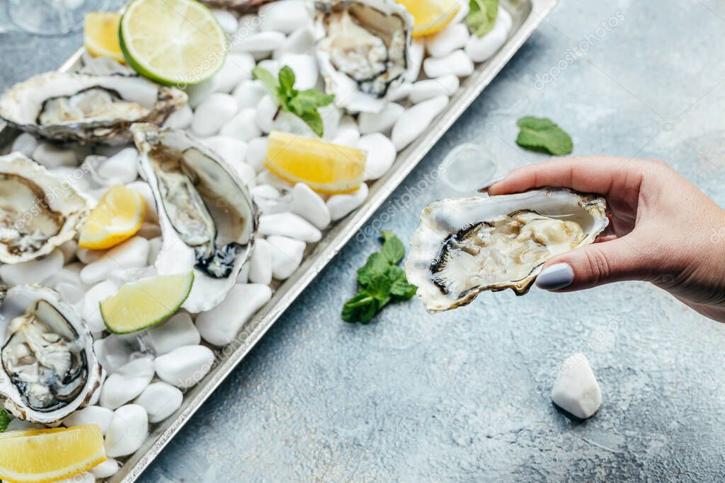 Oysters with wine, lemon, and a shucking knife. Oyster dinner with champagne in restaurant. banner, menu, recipe place for text, top view.