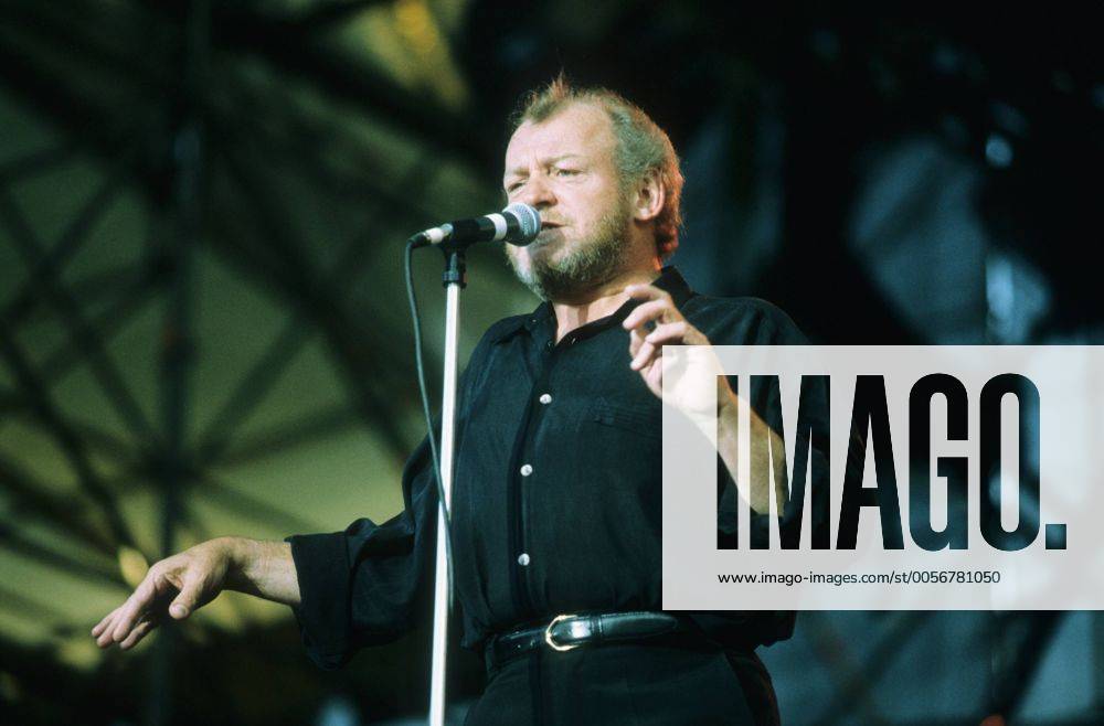 Joe Cocker 09 93 mat Mann Musik Gesang Pop Rock England quer halb stehend Bühne Kulisse leger dunkelhaarig Halbglatze Bart Mikrophon Hemd schwarz singend gestikulierend