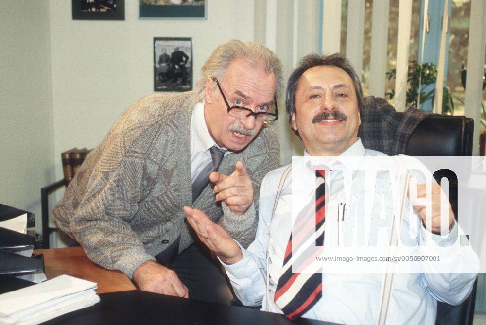 Wolfgang Stumph (re.) und Achim Wolff in Salto Kommunale (ZDF) 12 00 ker Mann Schauspieler Schauspiel TV Fernsehen Serie Film Komik grauhaarig kurzhaarig Schnäuzer leger Raum Zimmer Büro Amt Behörde Tisch Schreibtisch halb quer Szene Fototermin Salto Kommunale (Comedy-Serie, ZDF)