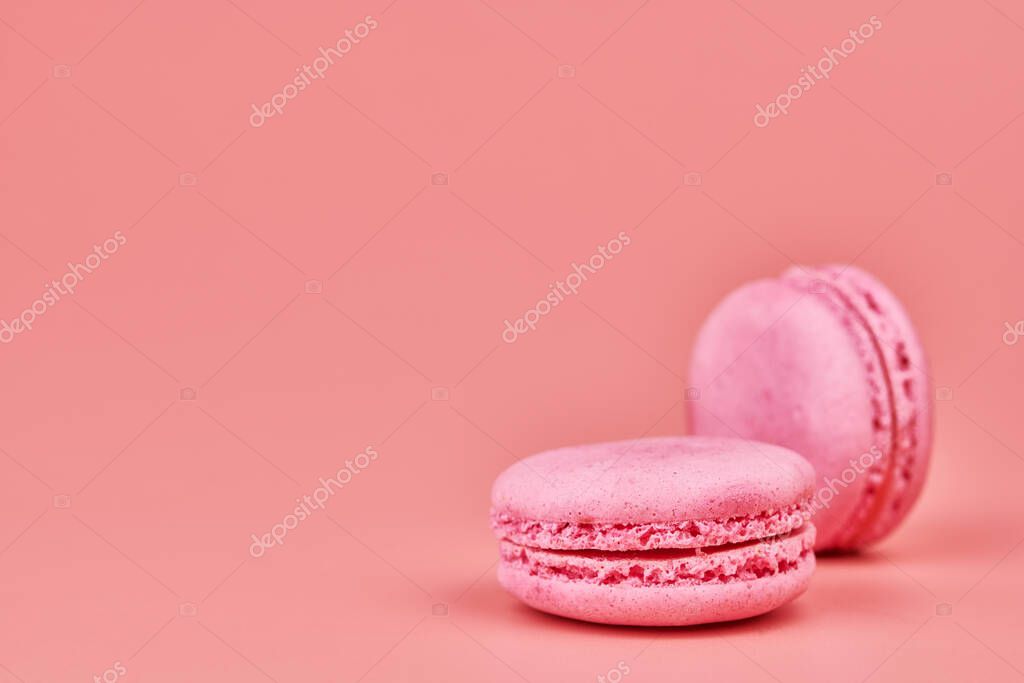 Macaroons on pink background. Colorful small cookie from ground almonds and coconut. Popular confectionery. Tasty snack food for take away, copy space