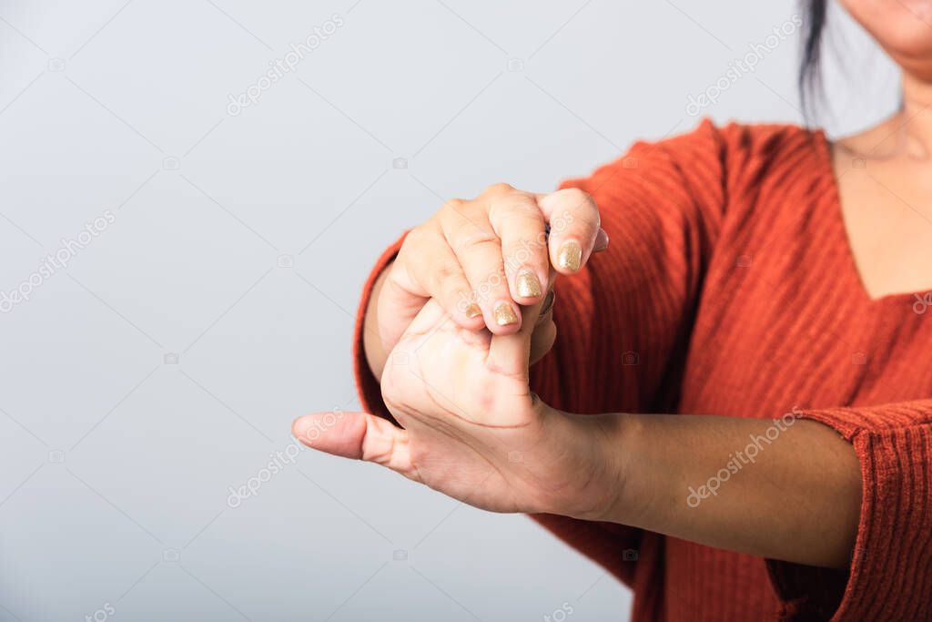 Close up hand of Asian woman she holding her acute pain in wrist of hands, studio shot isolated on white background, Healthcare medicine arthritis body care symptomatic office syndrome concept